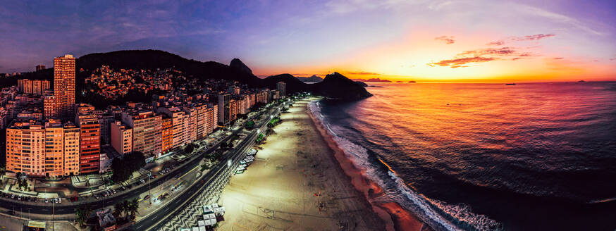 Panoramic aerial drone view of Leme Beach in the Copacabana district at sunrise with the iconic Sugarloaf Mountain in the background, UNESCO World Heritage Site, Rio de Janeiro, Brazil, South America - RHPLF25250