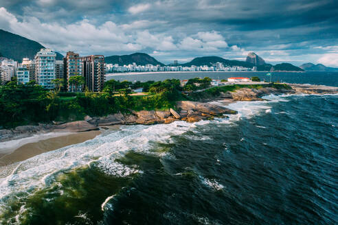 Aerial drone view of Arpoador section of Ipanema Beach with Copacabana and Sugarloaf Mountain visible in the background, Rio de Janeiro, Brazil, South America - RHPLF25255