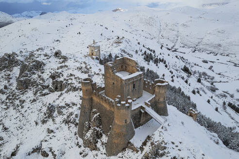 Close-up aerial view of the snow covered medieval castle of Rocca Calascio and the church of Santa Maria della Pieta� at dusk, Rocca Calascio, Gran Sasso e Monti della Laga National Park, Campo Imperatore, L'Aquila province, Abruzzo region, Italy, Europe - RHPLF25317