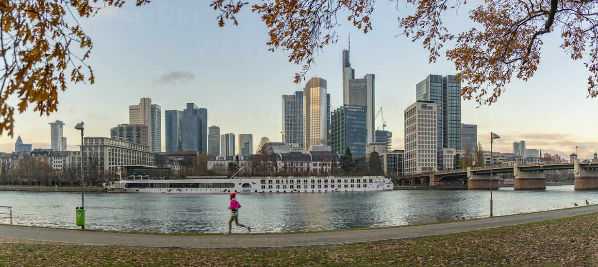 View of city skyline, jogger and River Main at sunset, Frankfurt am Main,  Hesse, Germany, Europe