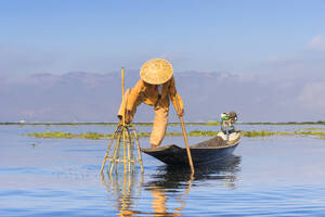 Fisherman with traditional conical net on boat, Lake Inle, Shan State, Myanmar (Burma), Asia - RHPLF25536