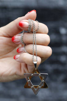 Close up on hands of woman with a Star of David (Jewish Star) pendant, Vietnam, Indochina, Southeast Asia, Asia - RHPLF25566