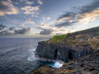 Cliff above the ocean, with a natural arch and small lighthouse, Farolim dos Fenais da Ajuda, Sao Miguel island, Azores islands, Portugal, Atlantic Ocean, Europe - RHPLF25661