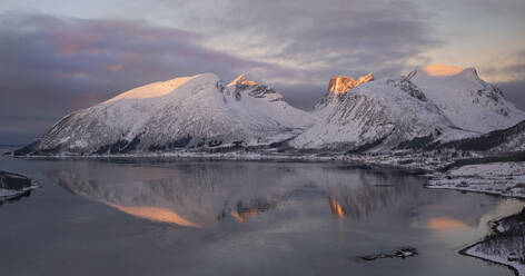 Dawn light over the village of Bergsbotn and Bergsfjord backed by the Bergsbotn mountain range in winter, Senja, Troms og Finnmark county, Norway, Scandinavia, Europe - RHPLF25687