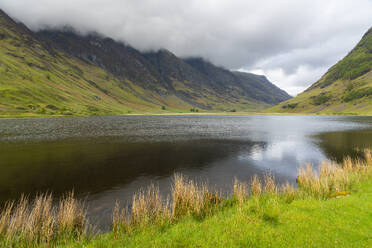 Loch Achtriochtan in valley against cloudy sky, Glencoe, Scottish Highlands, Scotland, United Kingdom, Europe - RHPLF25695
