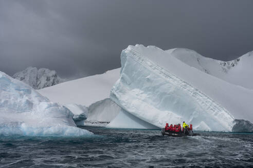 Tourists in an inflatable boat exploring Pleneau Island, Antarctica, Polar Regions - RHPLF25758