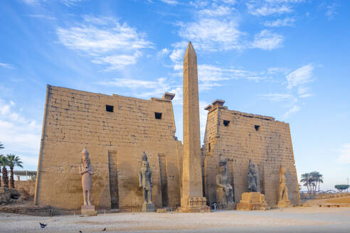 The Pylon of Ramesses ll with the Eastern Obelisk and the Two Colossi of the King seated on his Throne, Luxor Temple, Luxor, Thebes, UNESCO World Heritage Site, Egypt, North Africa, Africa - RHPLF25833