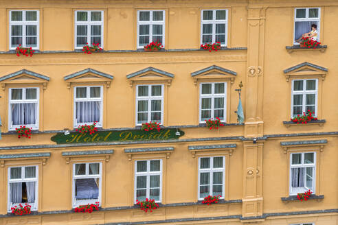 Woman sitting in window of house in historical center of Cesky Krumlov, UNESCO World Heritage Site, Cesky Krumlov, South Bohemian Region, Czech Republic (Czechia), Europe - RHPLF25990