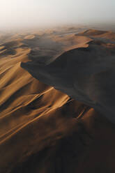 Aerial view of huge orange curvy dunes in desert with car in frame, Dune 7, Walvis Bay, Namibia. - AAEF18403