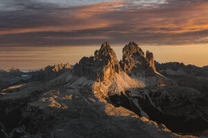 Aerial View of sunrise light at mountain tops of Tre Cime with amazing colours in the clouds, Dolomites, South Tyrol, Italy. - AAEF18414