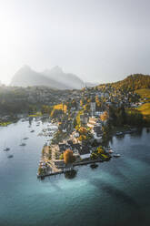 Aerial view of the harbour and castle of Spiez at late afternoon and sun dropping over the mountains, Lake Thun, Bern, Switzerland. - AAEF18422