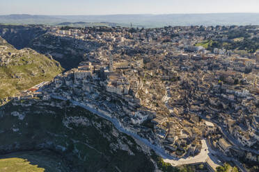 Aerial view of Sassi di Matera at sunlight, an ancient old town along the mountain crest, Matera, Basilicata, Italy. - AAEF18441