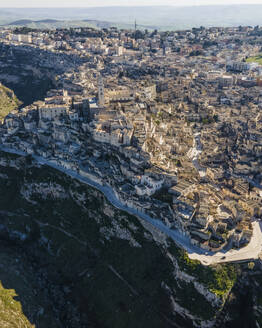 Aerial view of Sassi di Matera at sunlight, an ancient old town along the mountain crest, Matera, Basilicata, Italy. - AAEF18442