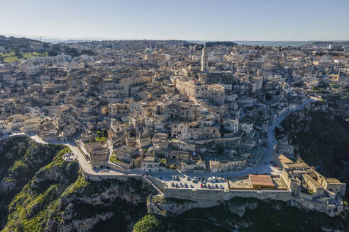 Aerial view of Sassi di Matera at sunlight, an ancient old town along the mountain crest, Matera, Basilicata, Italy. - AAEF18445