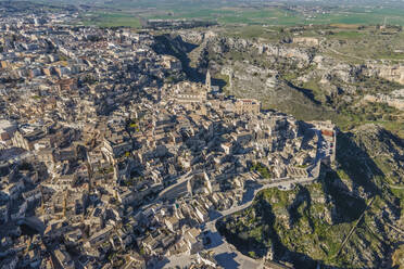 Aerial view of Sassi di Matera at sunlight, an ancient old town along the mountain crest, Matera, Basilicata, Italy. - AAEF18447
