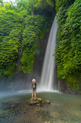 View of woman taking picture at Melanting waterfall, Kabupaten Buleleng, Gobleg, Bali, Indonesia, South East Asia, Asia - RHPLF26043