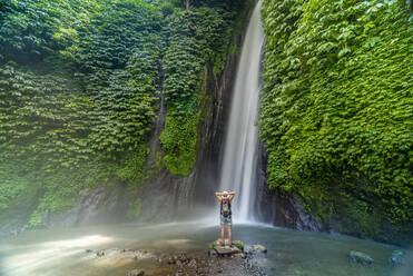 View of woman taking picture at Melanting waterfall, Kabupaten Buleleng, Gobleg, Bali, Indonesia, South East Asia, Asia - RHPLF26045