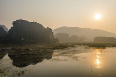 Aerial view of Khu Bao Ton hilly landscape with a swamp in foreground at sunset, Gia Vien, Vietnam. - AAEF18561