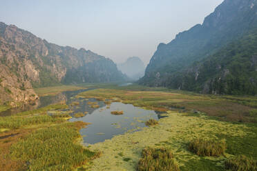 Aerial view of Khu Bao Ton mountains landscape with a swamp in foreground at sunset, Gia Vien, Vietnam. - AAEF18562