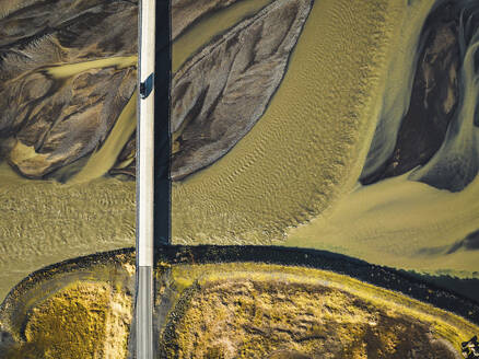 Aerial view of road crossing a glacial river on the southern region of Iceland. - AAEF18583