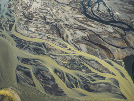 Aerial view of water formation pattern of a river along the coast in Eastern region, Iceland. - AAEF18585