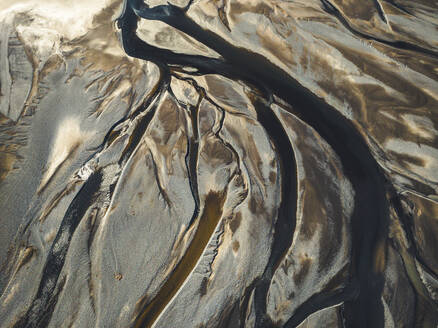 Aerial view of water formation pattern of a river along the coast in Eastern region, Iceland. - AAEF18586