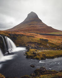 Aerial view of Mount Kirkjufell with waterfall and river in Iceland. - AAEF18591