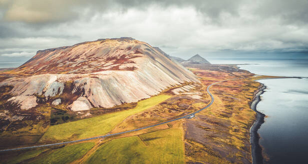 Aerial view of a scenic road along the coastline with mountains in Iceland. - AAEF18592