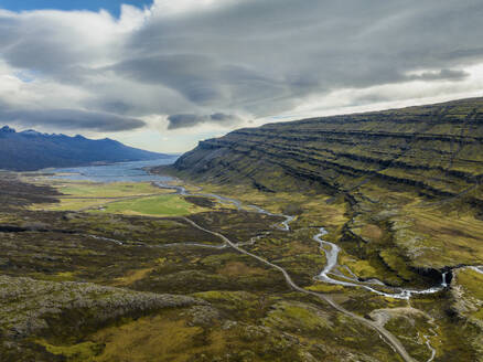 Aerial view of a river across the valley with mountains and a lake during a cloudy day, Iceland. - AAEF18619