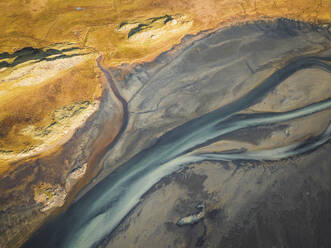Aerial view of water formation pattern of a river along the coast in Austurland, Iceland. - AAEF18632