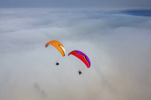 Aerial view of two paramotors flying above fog and clouds on the Black Sea coast of Istanbul, Turkey. - AAEF18789