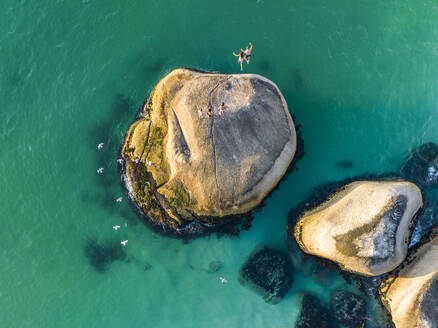 Aerial view of couple jumping off rock, Clifton, Cape Town, South Africa. - AAEF18856