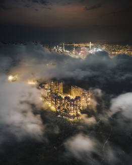 Aerial view of Hong Kong residential district at night with low clouds, Kowloon, China. - AAEF18877