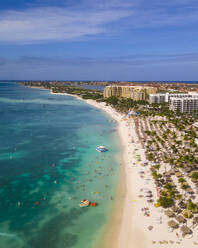 Aerial view of people on the beach along the shoreline with hotel buildings in Palm Beach in Aruba. - AAEF18923