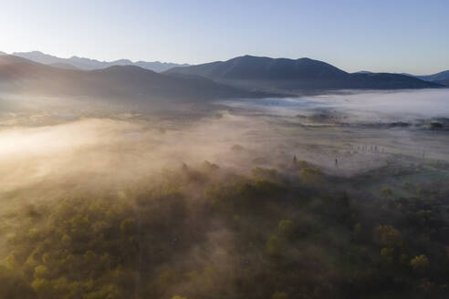 Aerial view of a valley with fog in early morning mist among mountains in Psaka, Epirus, Greece. - AAEF19034