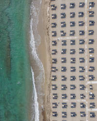 Aerial view of parasols on an empty beach in Fanari beach along the Thracian Sea, East Macedonia and Thrace, Greece. - AAEF19097