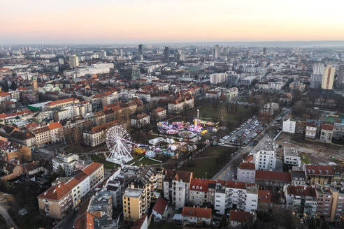 Aerial view of a theme park with Ferris wheel at Trg Franje Tudjmana park at sunset in Zagreb downtown, Croatia. - AAEF19154