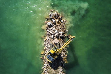 Aerial view of a crane working on the breakwater along the beach in Follonica, Grosseto, Tuscany, Italy. - AAEF19187