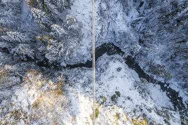 Aerial view of a footbridge crossing a small stream with snow in wintertime, Troistorrents, Valais, Switzerland. - AAEF19206