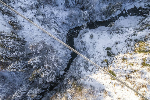 Aerial view of a footbridge crossing a small stream with snow in wintertime, Troistorrents, Valais, Switzerland. - AAEF19207