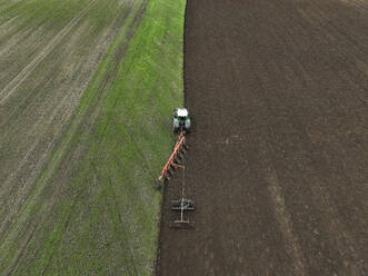 Aerial view of a tractor ploughing at a farm in Brandenburg, Germany. - AAEF19274