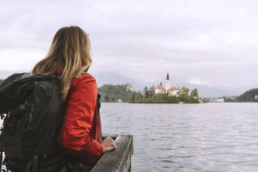 Rucksacktourist mit Blick auf das Meer an der Reling stehend - NDEF00697