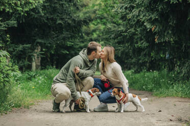 Mann und Frau küssen sich mit Jack Russell Terrier Hunden im Park - VSNF00944