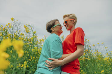 Happy lesbian couple embracing each other at field - VSNF00953