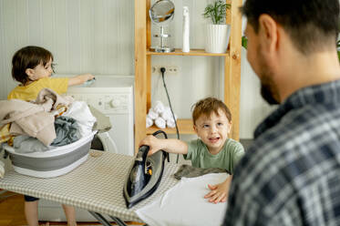 Father with son ironing clothes at home - ANAF01505