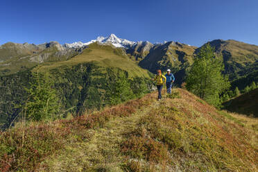 Man and woman hiking on mountain in Hohe Tauern National Park, Austria - ANSF00415