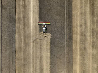 Aerial view of cereal harvesters and tractors at a farm in Brandenburg, Germany. - AAEF19333