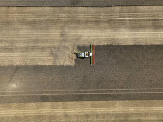 Aerial view of cereal harvesters and tractors at a farm in Brandenburg, Germany. - AAEF19334