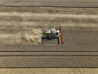 Aerial view of cereal harvesters and tractors at a farm in Brandenburg, Germany. - AAEF19338