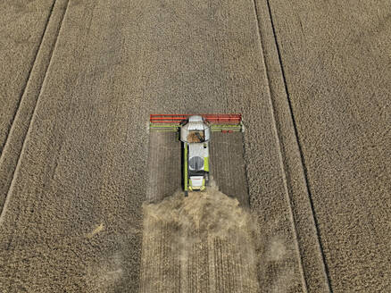 Aerial view of cereal harvesters and tractors at a farm in Brandenburg, Germany. - AAEF19345